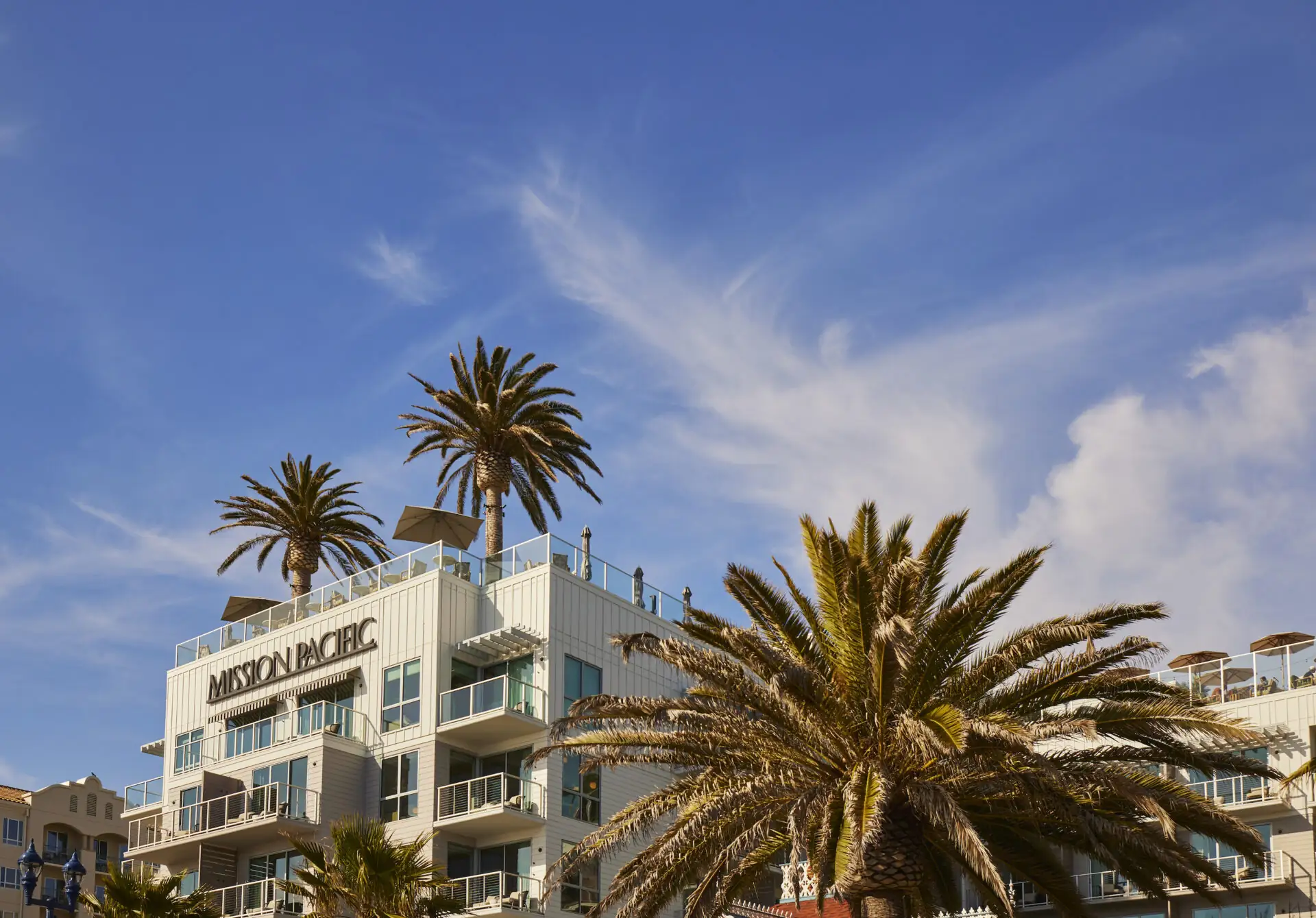 Frontal view of Mission Pacific Beach Resort, seen from the beach on a sunny day