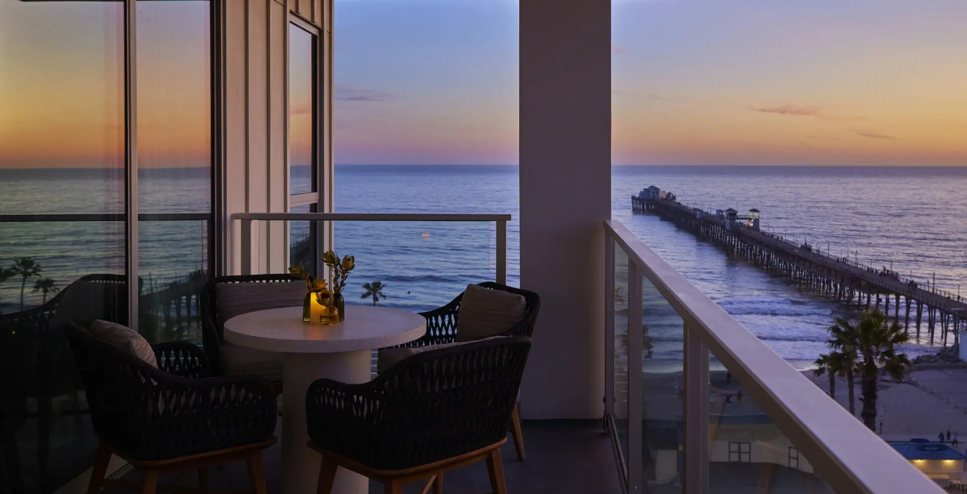 Ocean, pier, and beach views from a balcony of a room at mission pacific resort at sunset